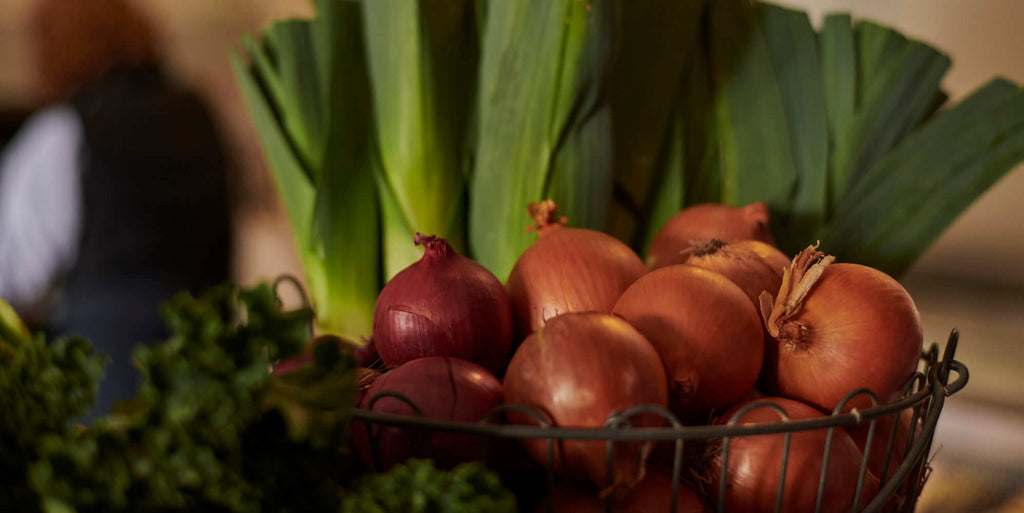 Onions and leeks on the produce table in Meatsmith Fitzroy