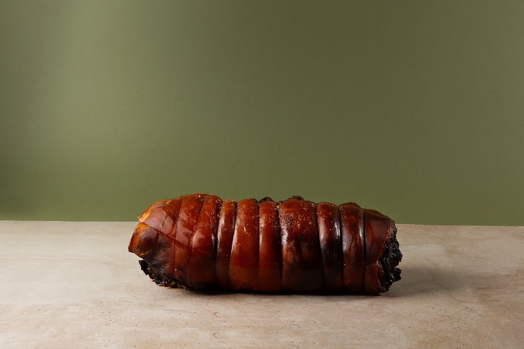 Suckling pig roast with pork farce, macerated fruits & mustard greens