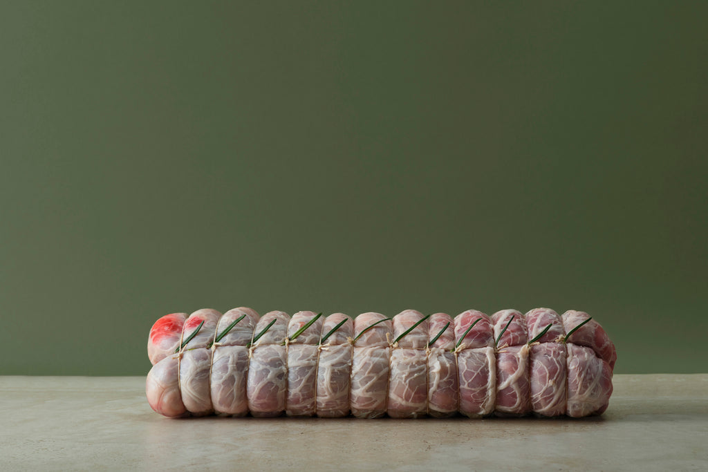 Rolled capretto saddle with confit garlic and Warrigal greens